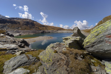 Fototapeta na wymiar lago nero all'alpe angeloga e il colore verde e le nuvole riflesse