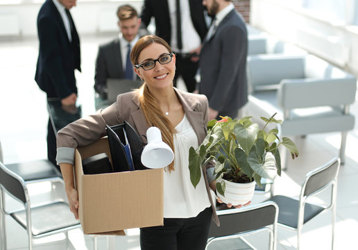 smiling business woman with personal things standing in modern office