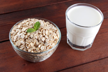 Oatmeal, milk and mint. Oat flakes on wooden boards. Milk and oatmeal for breakfast. Healthy food....