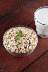 Oatmeal, milk and mint. Oat flakes on wooden boards. Milk and oatmeal for breakfast. Healthy food....