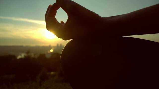The sky, the sun and the forest along with the grass on which the human sits are teaching him a lesson of silence. Fingers incircle the heart of this all, shining above and within. The lotus pose.