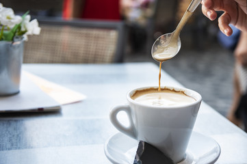 Young woman stirring a coffee
