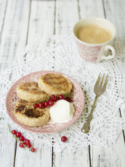 Cottage cheese pancakes with berries and sour cream, cup of black coffee, tasty breakfast, Copy space