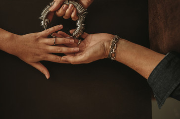 Jeweler checking ring finger size of female client
