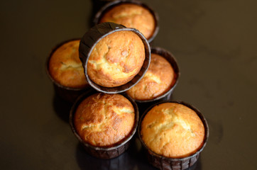 Six muffins in paper form on a dark background