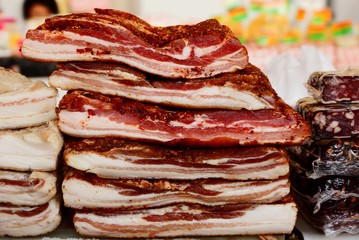 pieces of raw meat with lard on the counter in the heap