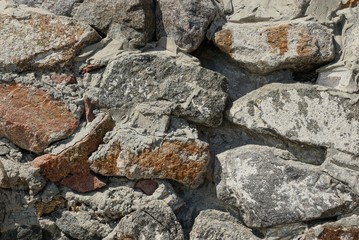 stone gray brown texture of large cobblestones in cement on the wall