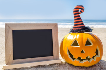Beach Halloween background with pumpkin in the witch's hats