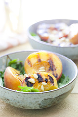 Grilled peach salad with arugula and pine nuts