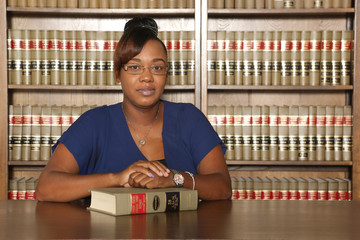 Professional woman in workplace, woman lawyer in law library.