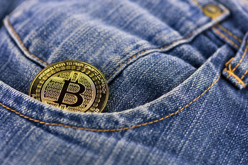 bitcoin coin in a blue jeans pocket