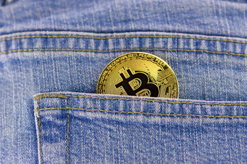 bitcoin coin in a blue jeans pocket
