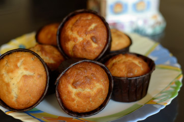 Seven vanilla muffins on a colored dish