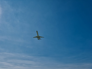 Fototapeta na wymiar Flugzeug in der Luft bei blauem Himmel mit wolken