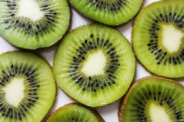 Fototapeta premium Kiwi fruit cut into pieces against a light background, close-up