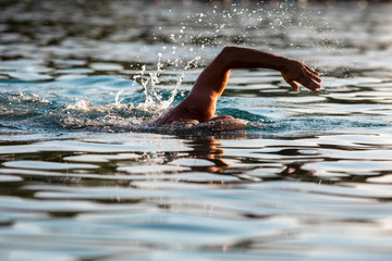 Swimmer hand over water. Swimming detail