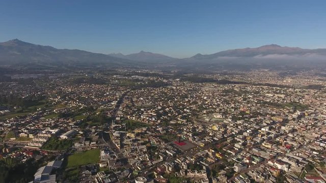 Aerial view of Sangolqui, Ecuador. In the Inter-Andean valley near Quito, Ecuador. Many volcanoes visible in background, including snowcapped Cotopaxi (at start of shot). 