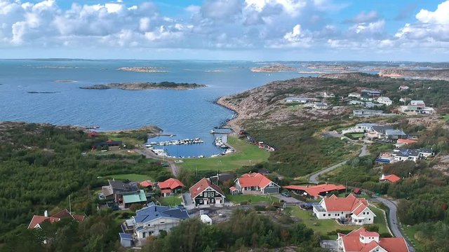 Aerial drone dolly overhead view shot of a rocky ocean coast line with suburbian housing on the west coast of Sweden in Kullavik outside of Gothenburg.