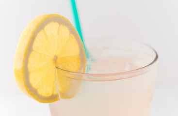 Pink strawberry lemonade in glass with green straw