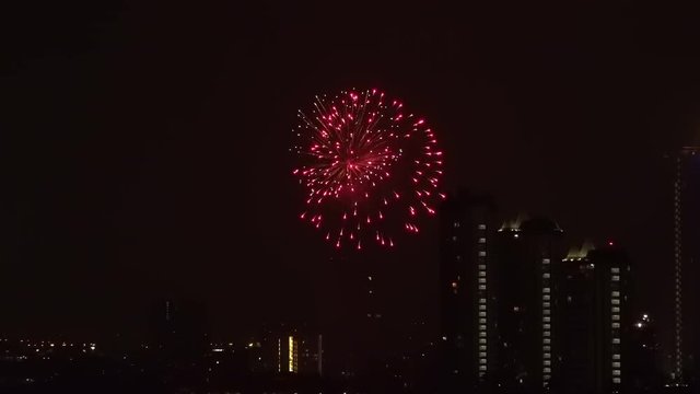Fantastic view of fireworks display over Bangkok. Amazing urban landscape with megalopolis buildings and festive pyrotechnic show in sky on background. Night cityscape during holiday celebration.