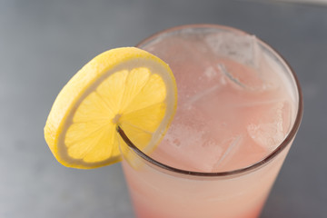 Pink strawberry lemonade in glass with green straw