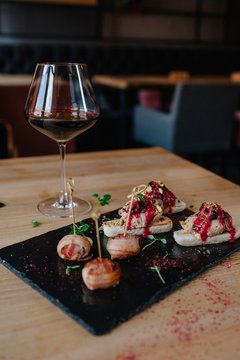 Glass of red wine next to a variety of appetizers