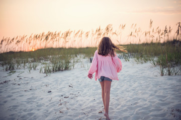 Girl walking on beach at sunset, Florida, United States