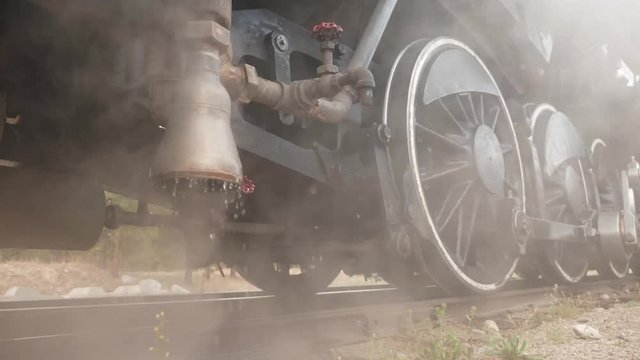 Vintage railway locomotive venting and dripping steam and water