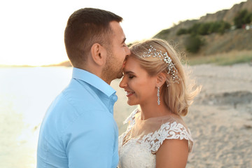 Wedding couple. Groom kissing bride on beach