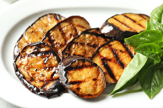 Plate with tasty fried eggplant slices, closeup