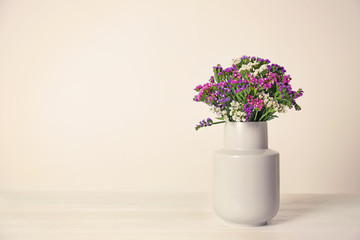 Beautiful flowers in vase and space for text on light background. Element of interior design