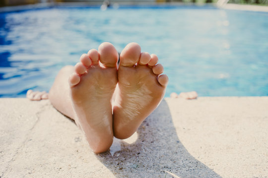 Boy lying in a swimming pool with his legs over the edge