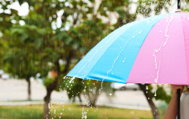 Person with bright umbrella under rain on street, closeup