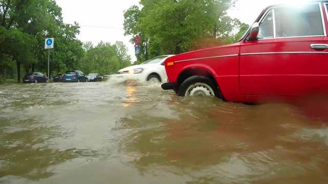 Cars passing a flooded intersection