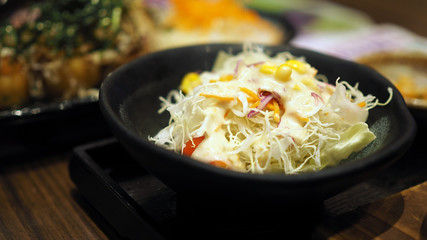 Lettuce salad in a black bowl.