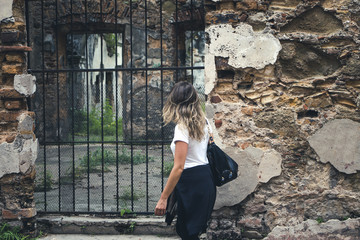 woman passing in front of an old building