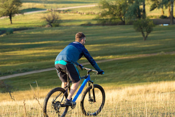 Obraz premium Cyclist in shorts and jersey on a modern carbon hardtail bike with an air suspension fork