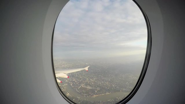 A view of early morning in London from the window of an arriving flight.