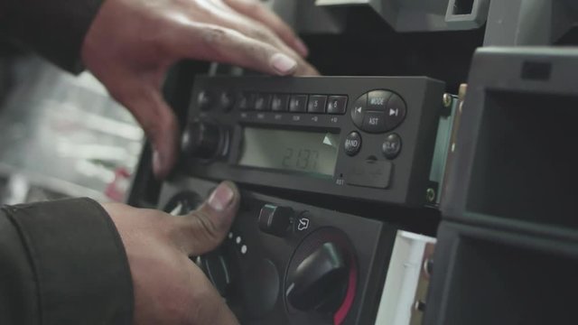 mechanic installing radio inside a car