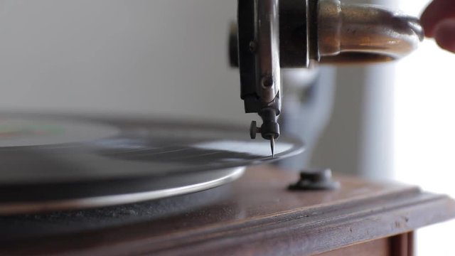 Record player or antique gramophone placing the needle on the record closeup.