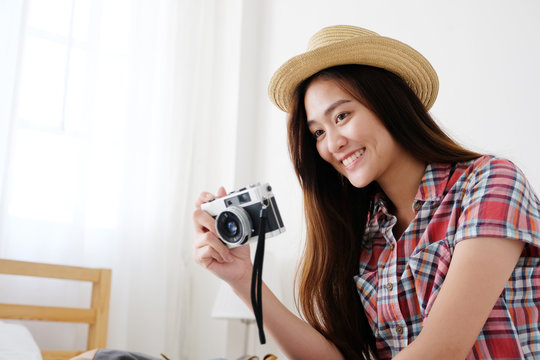Young asian woman holding vintage camera with smiling while preparing to travel, people positive expression, travel summer holiday vacation concept