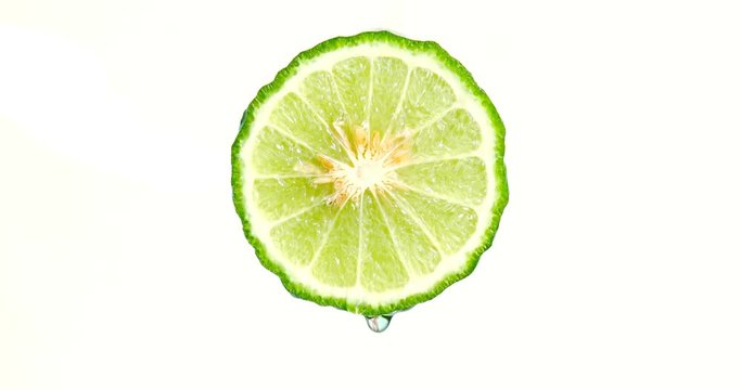 water or oils dropping on a lime slice , fruit for diet and healthy food