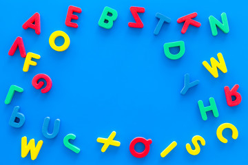 Alphabet for kids concept. English letters in disorder on blue background top view copy space