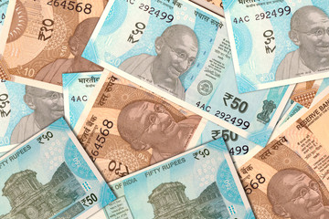 scattered Indian new 10 and 50 rupee currency notes.
