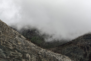 Misty clouds rise over mountain peaks in Waterton Lakes National Park, Canada