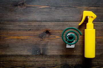 Mosquito protectors. Individual and for open space. Green spiral and spray on dark wooden...