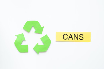 Types of matherial for reycle and reuse. Printed word cans near eco symbol recycle arrows on white background top view copy space