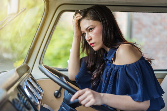stressed woman sitting inside vintage car