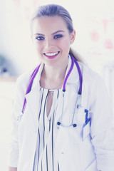 Smiling female doctor with a medical stethoscope in uniform standing