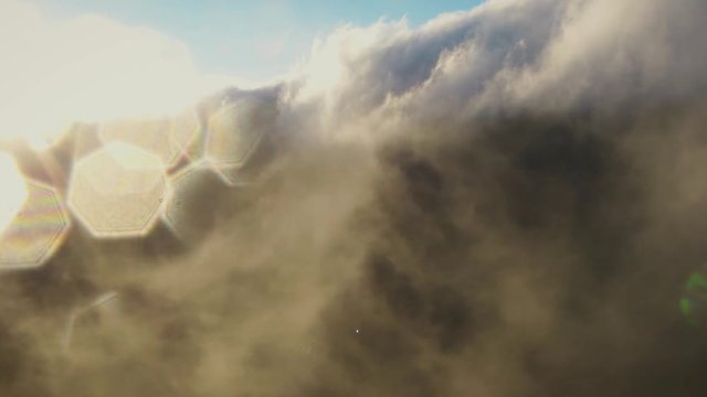 Aerial view of Mount Bromo located in East Java, flying through the clouds with dramatic backlight